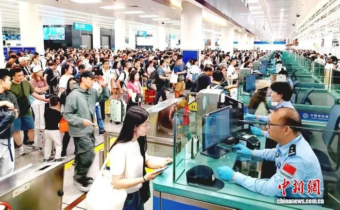 边检站民警为旅客办理查验手续。皇岗边检站供图